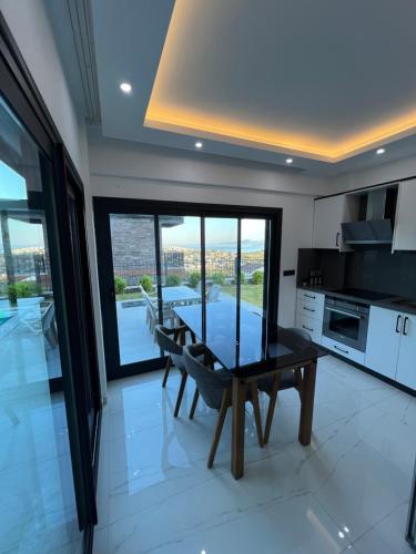 a dining room with a table and a kitchen at Villa Yakışıklı Bodrum vue mer avec piscine privée in Milas