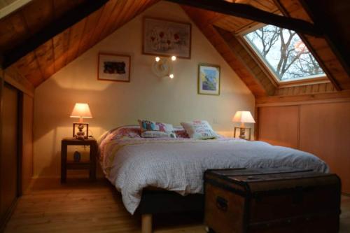 une chambre avec un lit dans un grenier dans l'établissement refuge de la chouette, à Saint-Gilles-Pligeaux