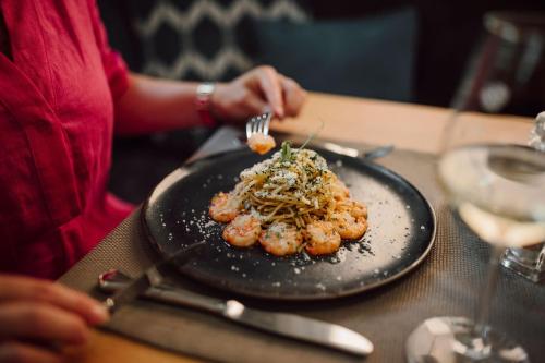 a person sitting at a table with a plate of food at Das gemütliche Dorfhotel Kaltenhauser in Hollersbach im Pinzgau