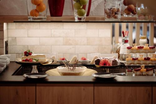 a kitchen with a counter with desserts on it at Das gemütliche Dorfhotel Kaltenhauser in Hollersbach im Pinzgau