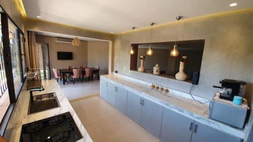 a large kitchen with a stove and a dining room at Ferme ADAM Agafay Marrakech in Marrakech