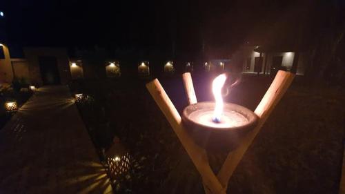 a candle in a wooden stand in the dark at Ferme ADAM Agafay Marrakech in Marrakech