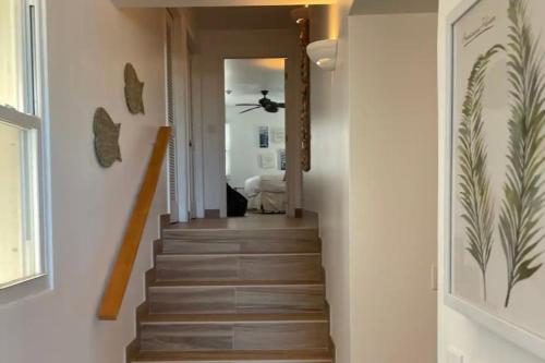 a staircase in a home with white walls and wooden floors at Luxury Beachfront Apartments Grace Bay Beach in The Bight Settlements