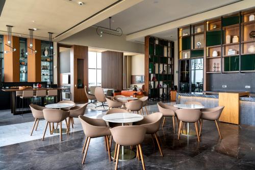 a restaurant with tables and chairs and a bar at JW Marriott Hotel Guadalajara in Guadalajara