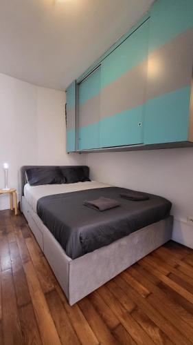 - une chambre avec un lit avec des armoires bleues et du parquet dans l'établissement Olympic Parc La Villette PARIS 19 Cosy Studio, à Paris