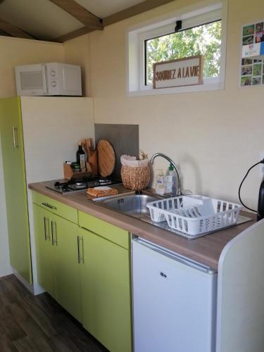 une cuisine avec un évier et un plan de travail dans l'établissement ROULOTTE AU COEUR DES ANIMAUX - Ecodomaine Rêver Ailleurs, à Champfrémont