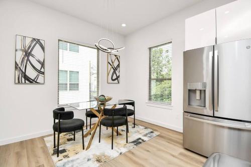 a kitchen and dining room with a table and a refrigerator at Chateau de Amour- Exquisite Townhouse - Medical Center, Downtown HTX in Houston