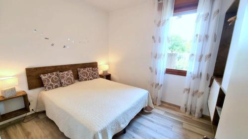 a white bedroom with a bed and a window at Cappuccini Appartments in Peschiera del Garda