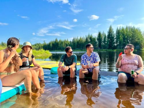 a group of people sitting on a raft in the water at Le Willow Exitchalets Lake, Billard & Spa in Val-David