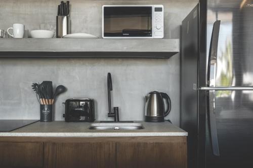 a kitchen with a sink and a microwave at Urbano by Sundara in Tulum