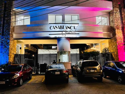 a building with cars parked in a parking lot at Suite CasaBlanca Grand, la mejor vista de Acapulco in Acapulco