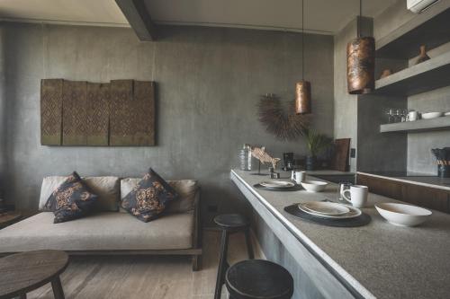 a kitchen with a couch and a counter with plates on it at Urbano by Sundara in Tulum