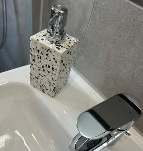 a cell phone sitting on a sink next to a mirror at neues trendy Appartement in Hannover in Hannover