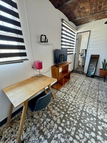 a room with a wooden table and a desk at Casa Hostal La Esperanza de Don Alfonso in León