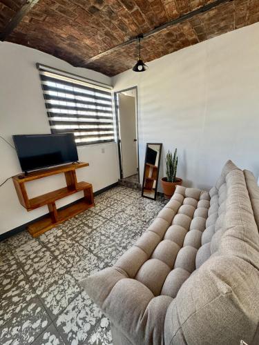 a living room with a couch and a flat screen tv at Casa Hostal La Esperanza de Don Alfonso in León