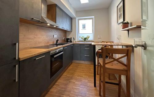 a kitchen with black cabinets and a wooden table at neues trendy Appartement in Hannover in Hannover