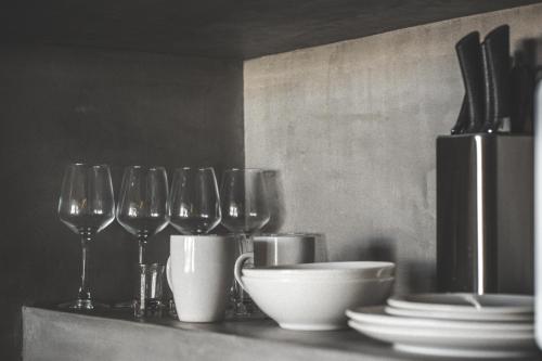 a group of wine glasses and plates on a counter at Urbano by Sundara in Tulum