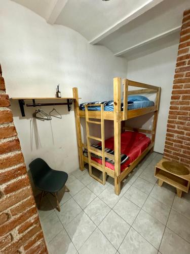 a room with bunk beds with a desk and a chair at Casa Hostal La Esperanza de Don Alfonso in León