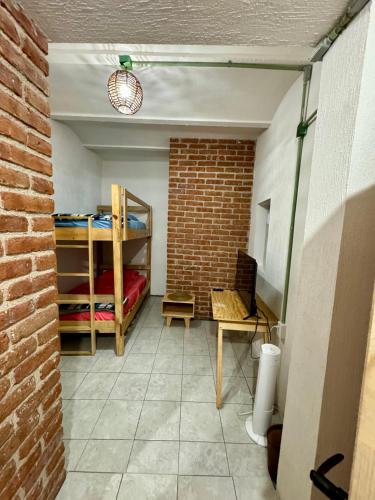 a room with bunk beds and a brick wall at Casa Hostal La Esperanza de Don Alfonso in León