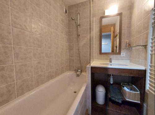 une salle de bain avec une baignoire, un lavabo et un miroir dans l'établissement Appartement 4-6p Belle Plagne, skis aux pieds, vue montagne, ensoleillé, à La Plagne Tarentaise