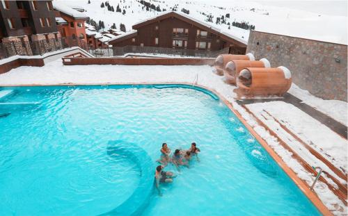 un groupe de personnes dans une piscine dans la neige dans l'établissement Appartement 4-6p Belle Plagne, skis aux pieds, vue montagne, ensoleillé, à La Plagne Tarentaise