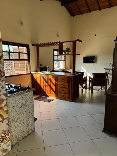 Una cocina grande con gabinetes de madera y una mesa. en Casa Campos, en Paraty