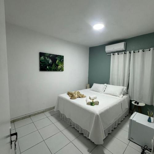 a bedroom with a bed with shoes on it at Pousada Recanto da Luísa in Paraty