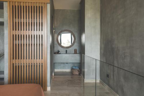 a room with a hallway with a mirror and a window at Urbano by Sundara in Tulum