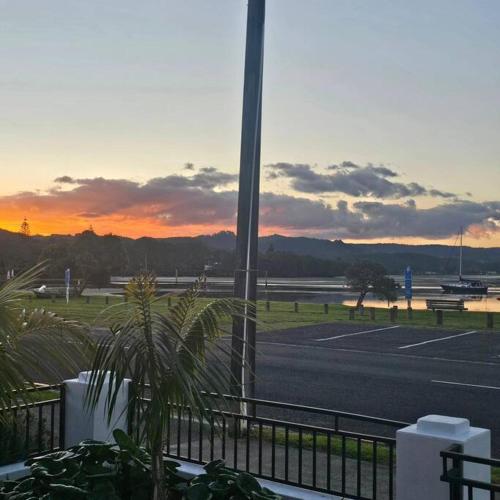 a view of a parking lot with a sunset at Whangamata Harbour Haven in Whangamata