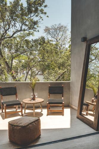 a patio with two chairs and a table and a mirror at Urbano by Sundara in Tulum