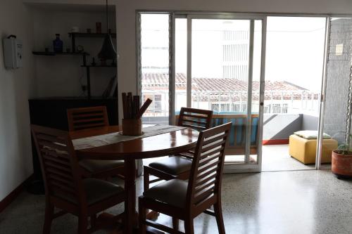 a wooden table and chairs in a room with a window at A1 Living Poblado Cómoda habitación privada in Medellín