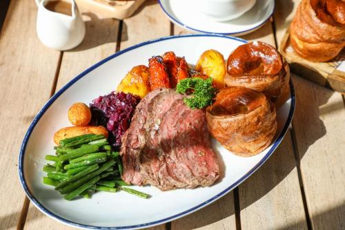 a plate of food with meat and vegetables and pastries at Park Inn by Radisson Dubai Motor City in Dubai