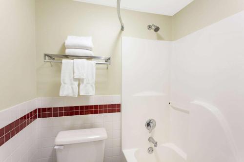 a bathroom with a toilet and a sink and towels at AmericInn by Wyndham St Cloud MN I-94 in Saint Cloud