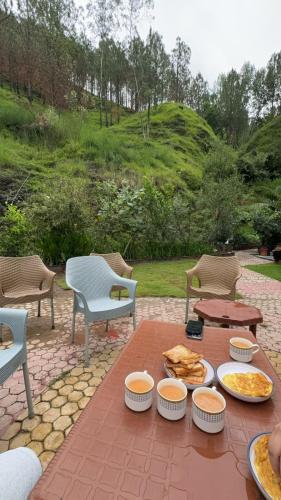 a table with plates of food on a patio at Hidden Resort Abbottabad in Abbottabad