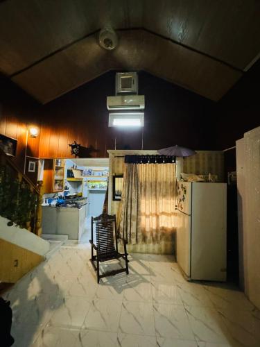 a kitchen with a chair and a refrigerator at Hidden Resort Abbottabad in Abbottabad