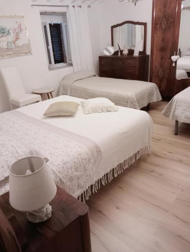 a bedroom with two beds and a table with a mirror at Il giardino dei sogni in Montefortino