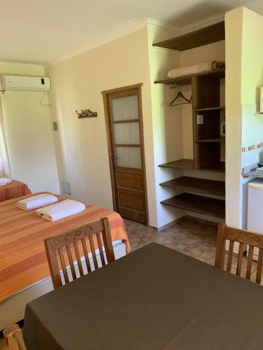 a room with two beds and a table and a kitchen at La Trinidad Casa de Campo in San José