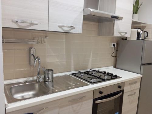 a kitchen with a sink and a stove and a refrigerator at B&B Guesthouse La Casetta Di Sutri sulla Francigena in Sutri