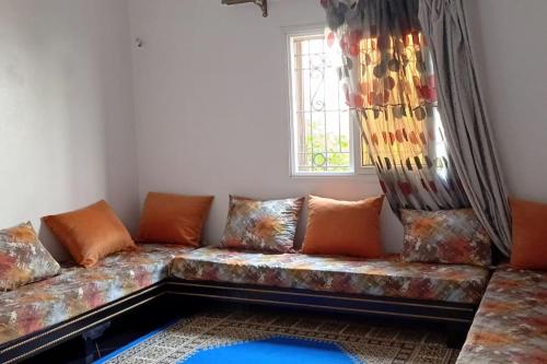 a couch sitting in a living room with a window at it is a calm place in Ghazoua