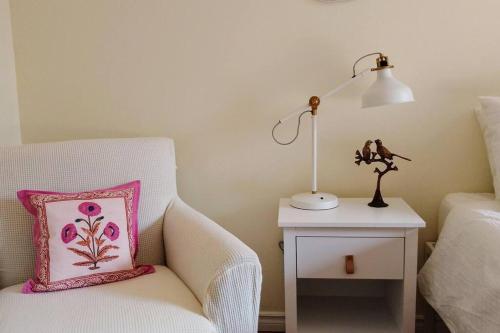 a bedroom with a chair with a pillow and a lamp at Birdsong Bungalow in Port Dover