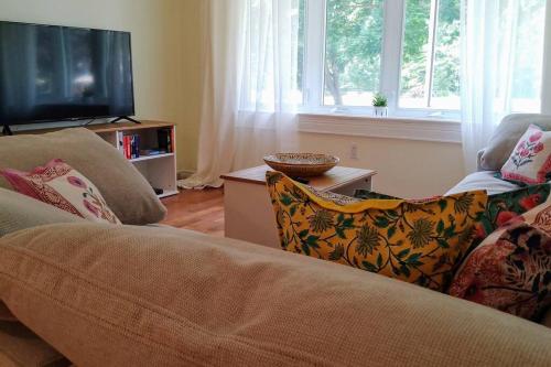 a living room with a couch and a flat screen tv at Birdsong Bungalow in Port Dover