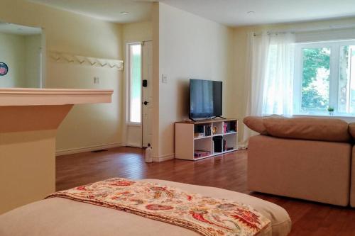 a living room with a couch and a television at Birdsong Bungalow in Port Dover
