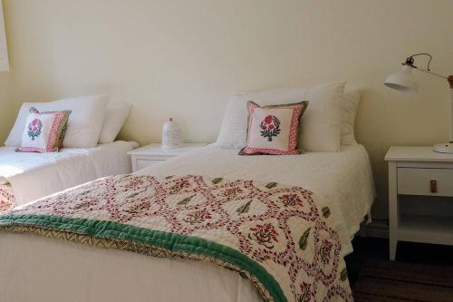 a bedroom with two beds with pink pillows at Birdsong Bungalow in Port Dover