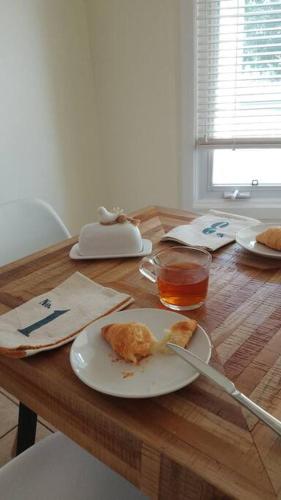 a wooden table with a plate of food on it at Birdsong Bungalow in Port Dover