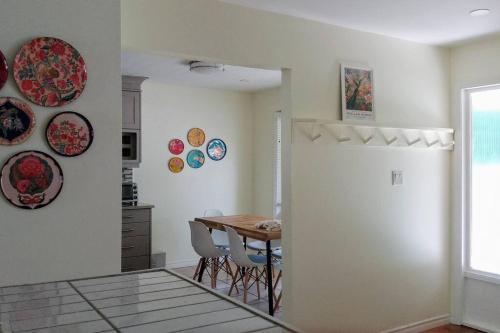 a kitchen and dining room with a table and plates on the wall at Birdsong Bungalow in Port Dover