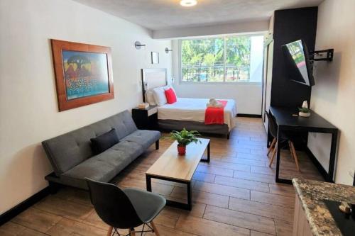 a small living room with a bed and a couch at DSt4 Well stocked studio in zone 15 in Guatemala