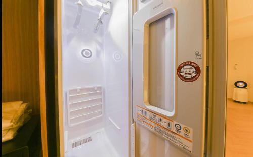 金海市The Van Hotel的一边有窗户的白色冰箱