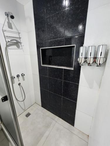 a bathroom with a shower and a black tile wall at Casa centrica, cómoda y amplia in Corrientes