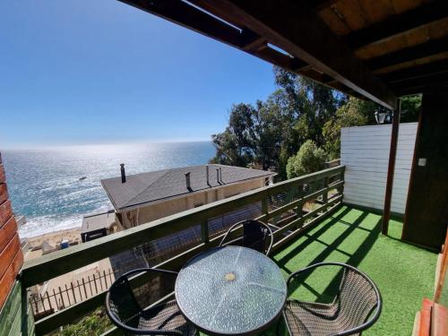 a table and chairs on a balcony overlooking the ocean at Al Mar Cabañas in Viña del Mar