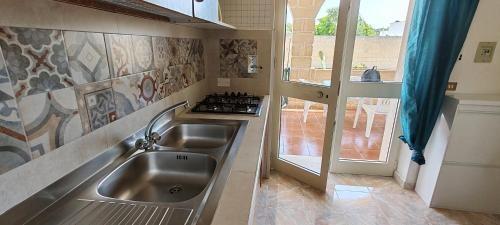 a kitchen with a sink and a stove at MAREE SOL RESIDENCE Camere e Appartamenti in Torre San Giovanni Ugento